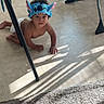baby, child, crawling, stitch, headband, costume, diaper, indoor, tiled_floor, living_room, chair, furniture, carpet, sunlight, shadows, portrait, face, curious, kneeling, playful