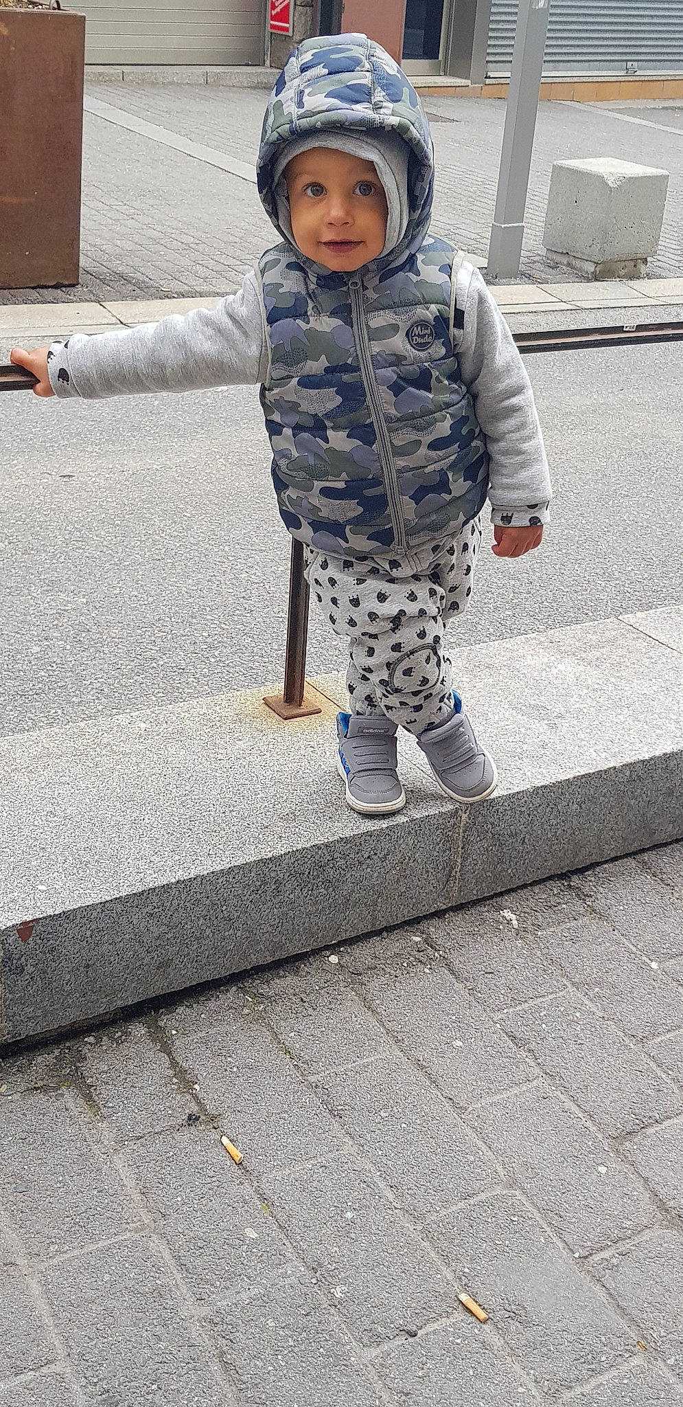 Sean participe au concours pour gagner de l'argent avec cette photo : asphalt, child, headwear, jeans, outerwear, pattern, person, play, shoe, sidewalk, smile, snapshot, street_fashion, toddler