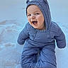 baby, child, snow, winter_clothing, snowsuit, hood, smile, happy, outdoor, cold_weather, infant, cute, playful, nature, seasonal, fun, face, person, sitting, blue