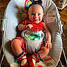 baby, child, infant, smiling, happy, portrait, headband, bunny_ears, red_clothing, bib, elephant, bouncer, high_chair, seated, indoors, home, carpet, colorful, toy, family_photo