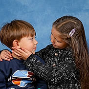 Kenza participe au concours pour gagner de l'argent avec cette photo : child, children, boy, girl, face, portrait, love, affection, tenderness, hair_clip, long_hair, short_hair, sweater, blue_background, studio, cute, smiling, friendship, family, interaction