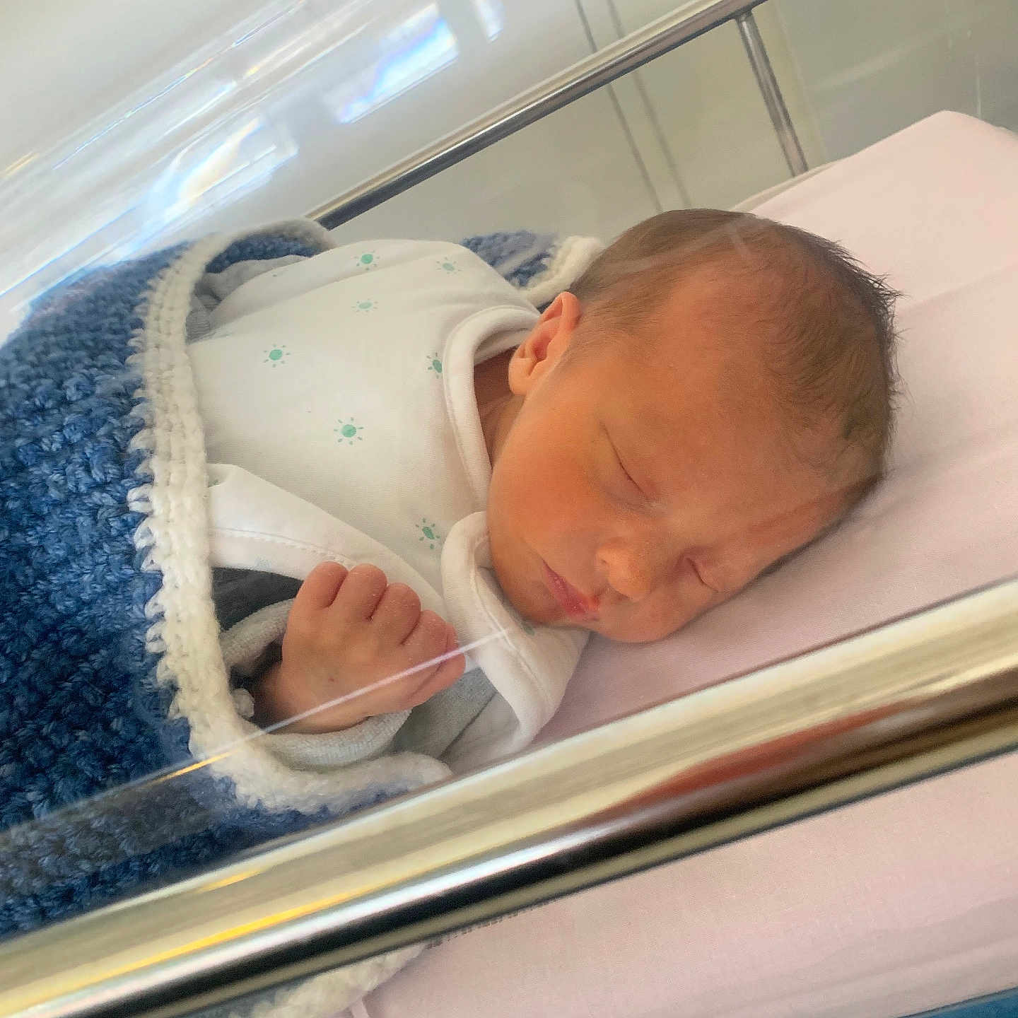 Ethan participe au concours pour gagner de l'argent avec cette photo : baby, bassinet, bed, blanket, blue, clothing, cute, face, hand, healthcare, hospital, indoor, infant, newborn, newborncare, person, pink, portrait, resting, sleeping