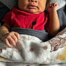 baby, infant, blanket, red_shirt, face, hand, portrait, cute, cozy, teddy_bear_pattern, banana_pattern, sleeping_bed, child, newborn, skin, expression, indoors, soft_texture, clothing, person