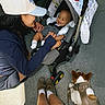 Austin Beirge is registered to the contest to win money with this photo: baby, car_seat, woman, cap, dog, harness, pavement, legs, shoes, socks, smile, happy, outdoor, person, infant, pet, canine, leash, casual, interaction