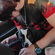 Roscoe joined the competition — help win amazing prizes! person, dog, puppy, black_and_white, watch, phone, sitting, lap, casual_clothing, human_hand, indoor, closeup, pet, affection, relaxation, companion, technology, red_shirt, chain_necklace, watch_face