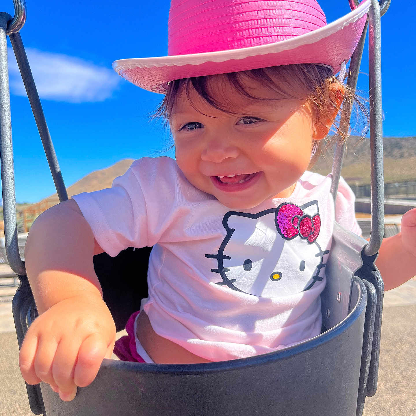 Zora is registered to the contest to win money with this photo: baby, cap, clothing, face, grass, hat, head, nature, outdoorplayarea, outdoors, park, person, photography, plant, playarea, portrait, sunhat, swing, t_shirt, toy