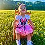 Emery joined the competition — help win amazing prizes! toddler, child, smiling, outdoor, grass, sunlight, blue_sky, dress, pink, white_shoes, wooden_chair, green_field, happy, face, portrait, cute, nature, daylight, bow, sitting
