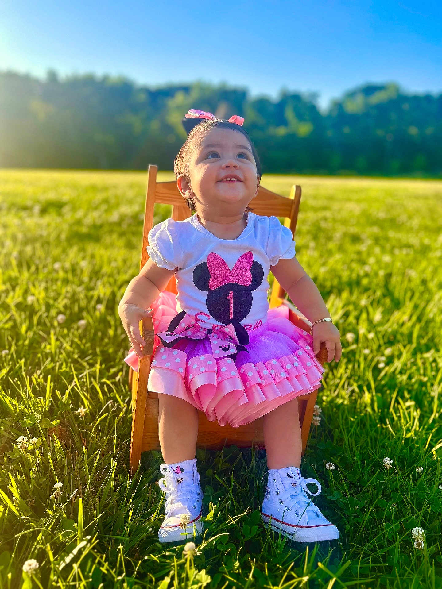 Emery joined the competition — help win amazing prizes! toddler, child, smiling, outdoor, grass, sunlight, blue_sky, dress, pink, white_shoes, wooden_chair, green_field, happy, face, portrait, cute, nature, daylight, bow, sitting