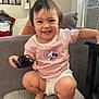 Emery is registered to the contest to win money with this photo: toddler, child, smiling, squatting, sunglasses, pink_shirt, white_shorts, couch, living_room, photo_frame, lamp, window, air_conditioner, bracelet, earrings, happy, indoor, furniture, person, home