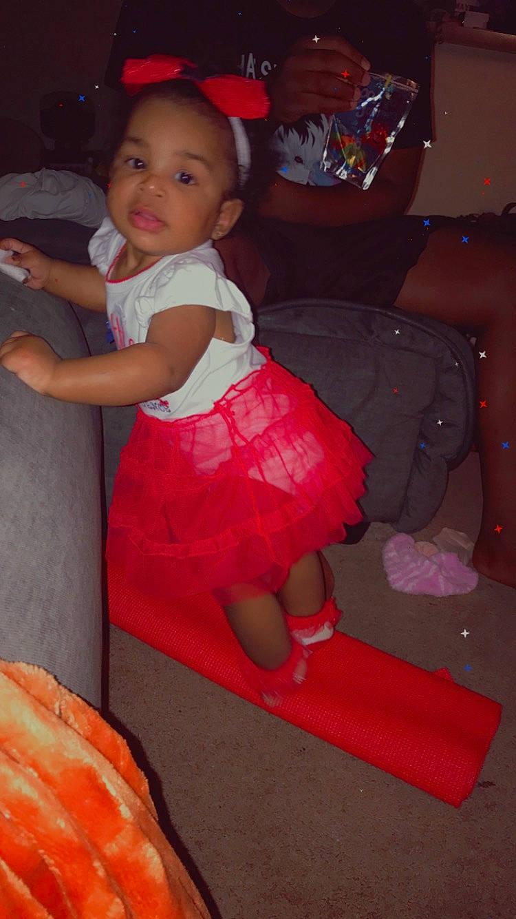 Belle is registered to the contest to win money with this photo: baby_toddler_clothing, face, flooring, fun, happy, human_body, human_leg, lap, leg, magenta, person, pink, red, skin, smile, sock, textile, thigh, toddler, trunk