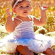 Lisa is registered to the contest to win money with this photo: baby, child, white_dress, headband, outdoor, grass, blanket, sunlight, cute, portrait, sitting, happy, infant, nature, summer, smile, young_child, one_person, young_baby, beauty