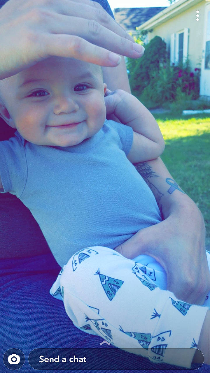 Uriah is registered to the contest to win money with this photo: arm, baby, blue, cheek, child, cool, eye, facial_expression, grass, happy, head, headwear, joy, people, person, plant, play, skin, smile, summer