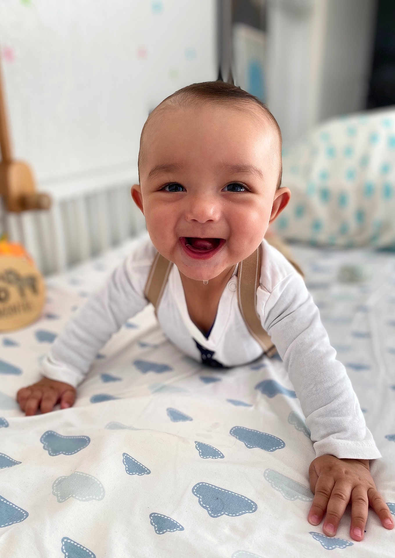 Sloan a rejoint le concours — aidez-le/la à gagner de superbes lots ! baby, smiling, crawling, bed, drool, white_clothing, patterned_sheet, indoor, child, happy, infant, cute, face, hands, furniture, home, portrait, person, young_child, baby_boy