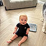 Cass is registered to the contest to win money with this photo: baby, child, floor, wooden_floor, romper, ankle_bracelet, blue_eyes, couch, pillow, tablet, dog_paw, pet, indoor, home, flooring, smiling, sitting, curious, cute, furniture