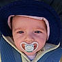baby, pacifier, hat, car_seat, blue_eyes, clothing, straps, infant, cute, closeup, face, child, seatbelt, smiling_pacifier, headwear, baby_jacket, portrait, young_child, comfort, outdoor