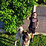 Tchado participe au concours pour gagner de l'argent avec cette photo : boy, canine, casual_clothing, child, daytime, dog, fence, grass, greenery, happy, leisure, nature, outdoor, pet, playful, portrait, smiling, summer, sunlight, tree