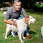 Pomm a rejoint le concours — aidez-le/la à gagner de superbes lots ! man, dog, pet, leash, grass, park, bench, smile, portrait, outdoor, sunlight, gray_hair, polo_shirt, jeans, brown_shoes, kneeling, happy, canine, owner, animal