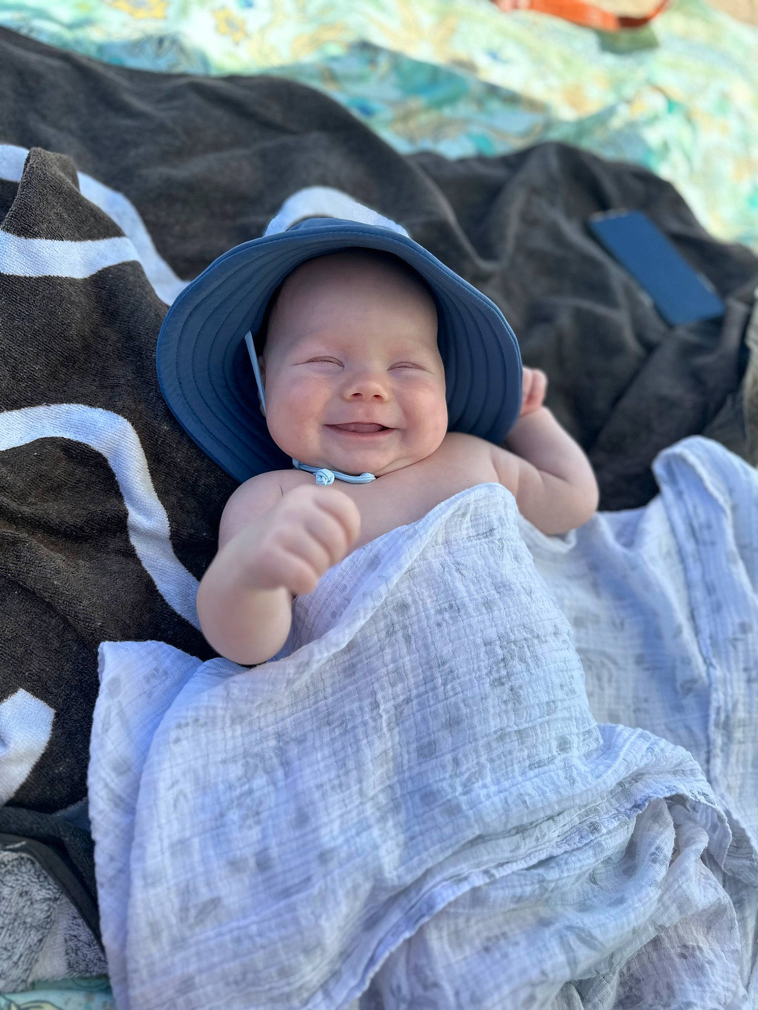 Henry is registered to the contest to win money with this photo: baby, baby_toddler_clothing, child, comfort, face, grass, happy, headwear, joy, linens, pattern, person, product, sitting, sleeve, smile, textile, toddler, tree
