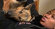Pepsie is registered to the contest to win money with this photo: person, dog, german_shepherd, cuddle, indoor, cozy, black_jacket, leopard_print, wall, power_outlet, rope, relaxing, affection, pet, animal, portrait, casual, smile, resting, friendship