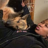 person, dog, german_shepherd, cuddle, indoor, cozy, black_jacket, leopard_print, wall, power_outlet, rope, relaxing, affection, pet, animal, portrait, casual, smile, resting, friendship