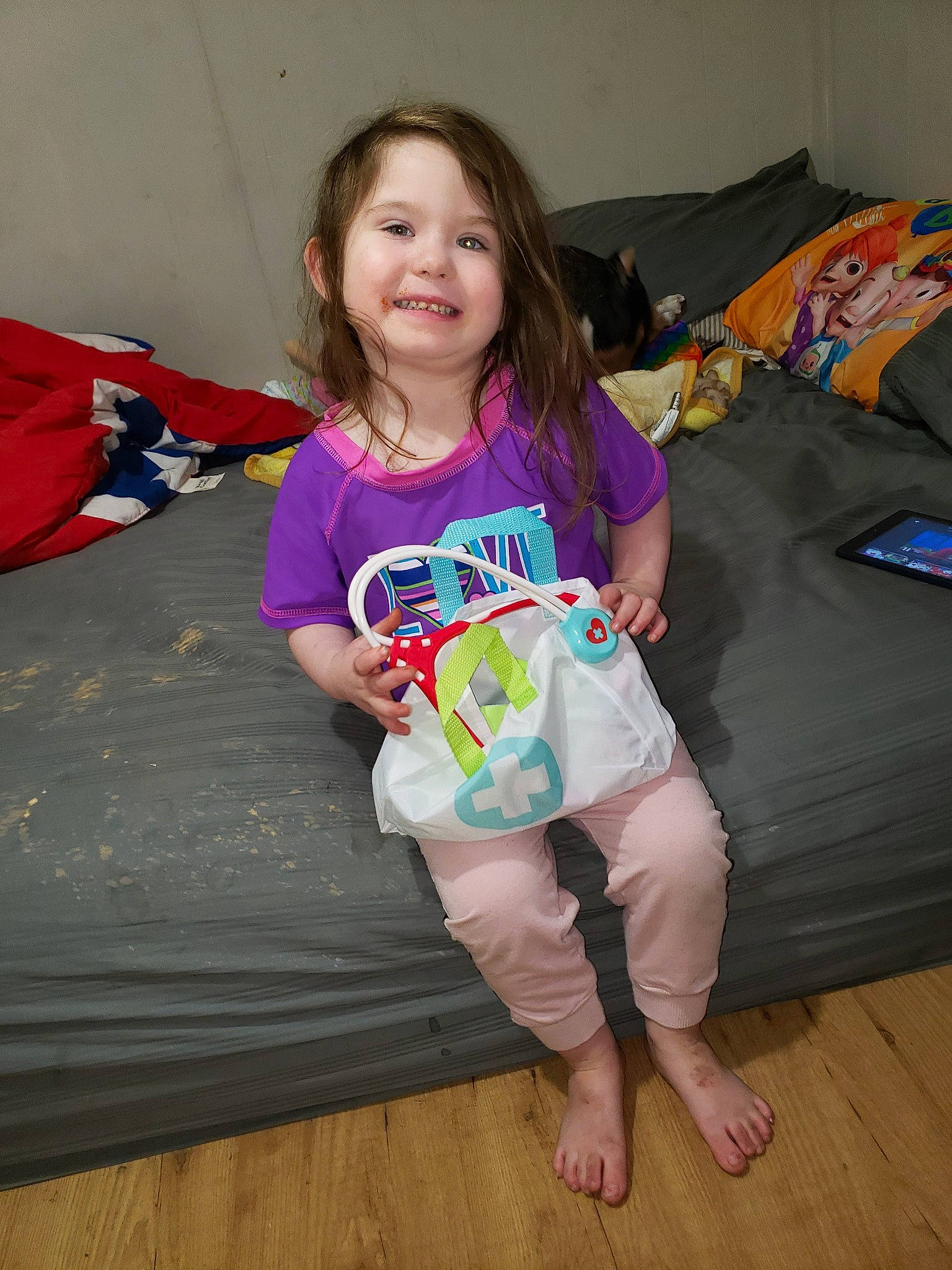 Ina is registered to the contest to win money with this photo: baby_toddler_clothing, barefoot, child, comfort, couch, floor, flooring, fun, happy, hardwood, human_leg, joy, pajamas, person, sitting, sleeve, smile, t_shirt, textile, thigh