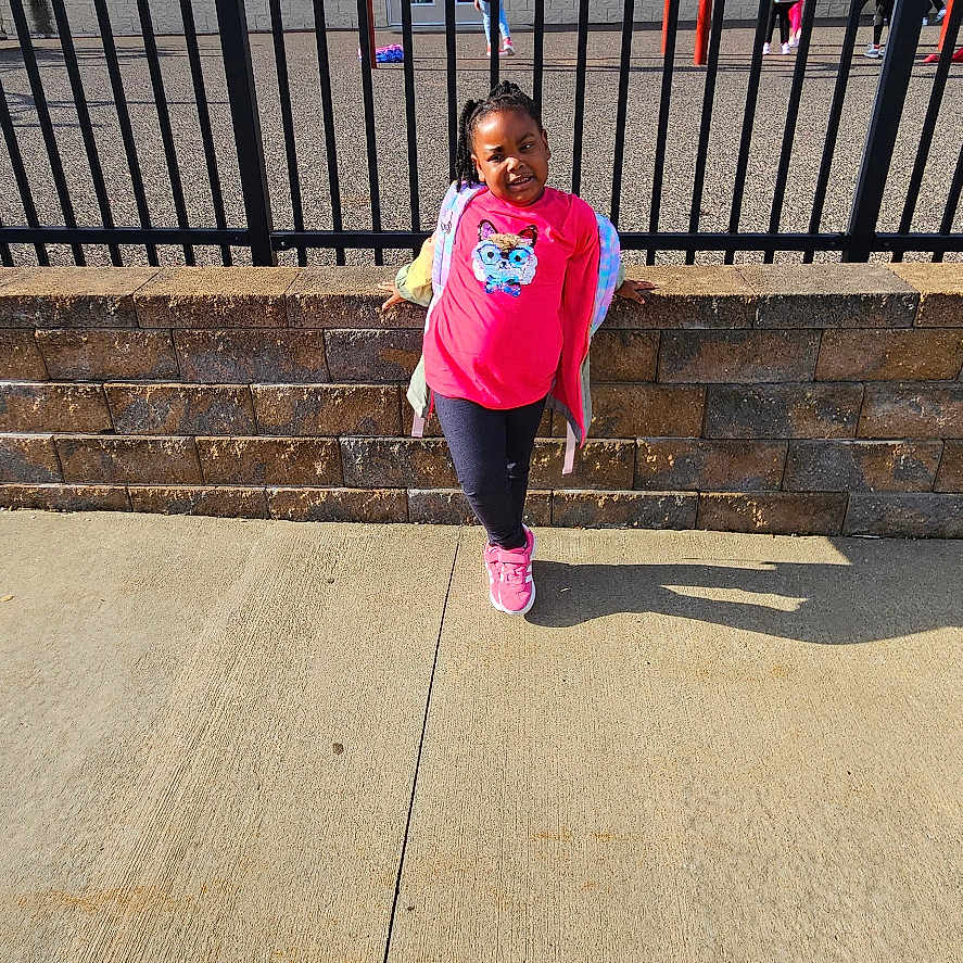 Riley is registered to the contest to win money with this photo: architecture, building, child, clothing, face, female, fence, footwear, girl, head, outdoors, pants, person, photography, portrait, railing, shelter, shoe, t_shirt, walking
