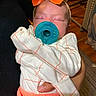 Ahzara Ourlanii is registered to the contest to win money with this photo: baby, newborn, pacifier, bow, sleeping, infant, clothing, orange, hand, person, indoor, blanket, cute, resting, child, portrait, soft_lighting, holding, cozy, toddler