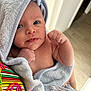 baby, infant, towel, wrapped, fist, skin, cute, portrait, person, indoor, closeup, newborn, soft, expression, head, face, hand, colorful, striped, fabric
