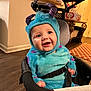baby, babylaughing, bonnet, cap, chair, clothing, coat, costume, face, furniture, happy, hat, head, homedecor, hood, person, photography, portrait, rug, smile