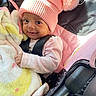 Harmony is registered to the contest to win money with this photo: baby, blanket, car_seat, child, clothing, cozy, cute, face, happy, hat, indoors, infant, person, pink, pom_pom, portrait, seatbelt, smiling, sunlight, toddler