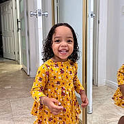 Kattleya joined the competition — help win amazing prizes! child, toddler, girl, smiling, happy, portrait, standing, floral_dress, yellow_clothing, curly_hair, indoors, hallway, mirror, reflection, closet, door, tile_floor, home, fashion, photography