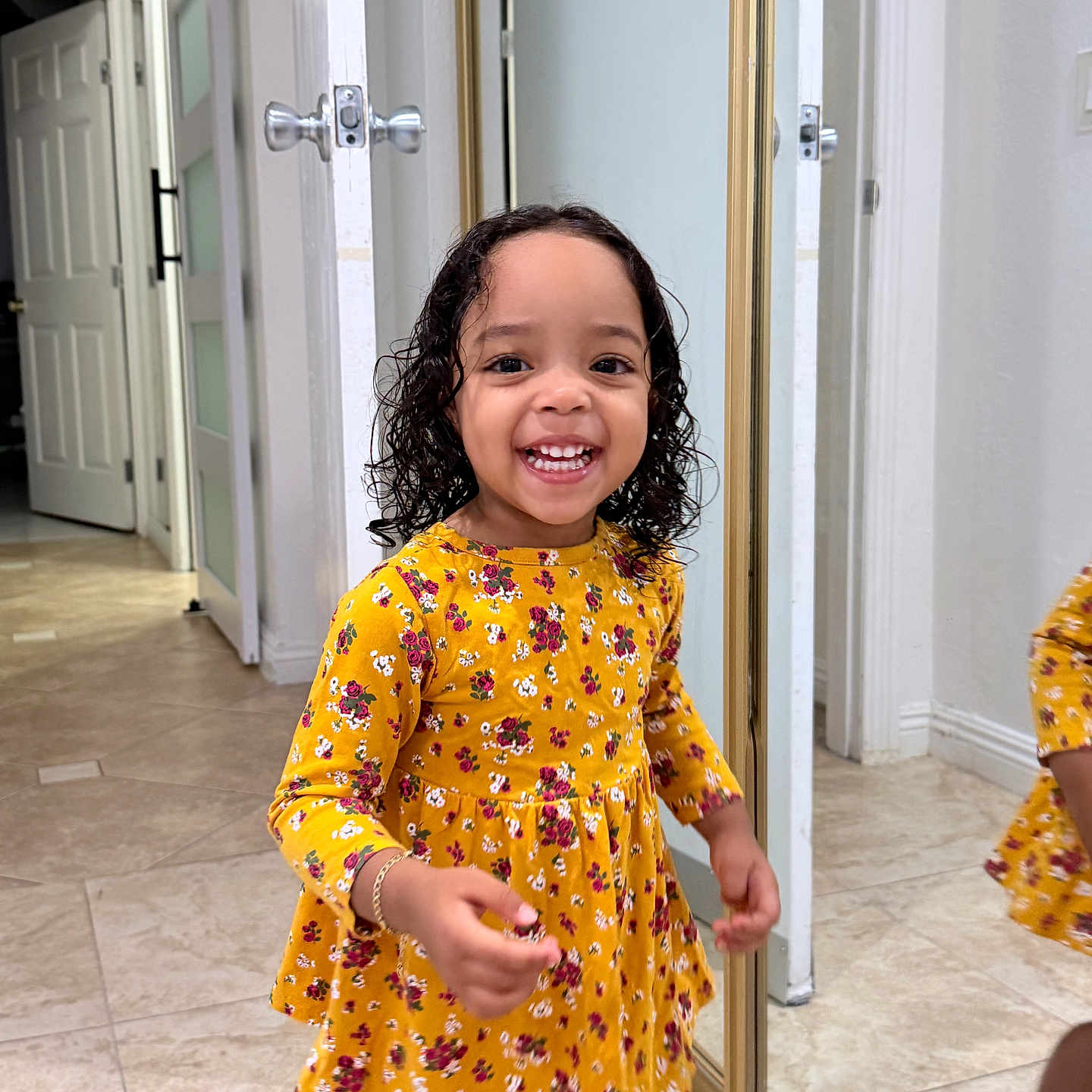 Kattleya joined the competition — help win amazing prizes! child, toddler, girl, smiling, happy, portrait, standing, floral_dress, yellow_clothing, curly_hair, indoors, hallway, mirror, reflection, closet, door, tile_floor, home, fashion, photography