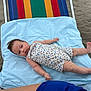 baby, infant, beach, sand, beach_chair, blue_cloth, floral_outfit, relaxing, lying_down, child, cute, person, summer, outdoor, skin, head, feet, arms, legs, hair