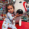Aniyah joined the competition — help win amazing prizes! child, toddler, pajamas, toy_store, statue, dog_statue, red_target, smiling, curly_hair, indoor, colorful, clothing, playful, happy, person, retail, shopping, holiday_theme, cute, kid