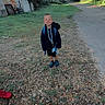 child, boy, smiling, backpack, school, outdoor, rural, road, gravel, grass, trees, greenery, building, garage, outbuilding, summer, daylight, portrait, standing, shoes