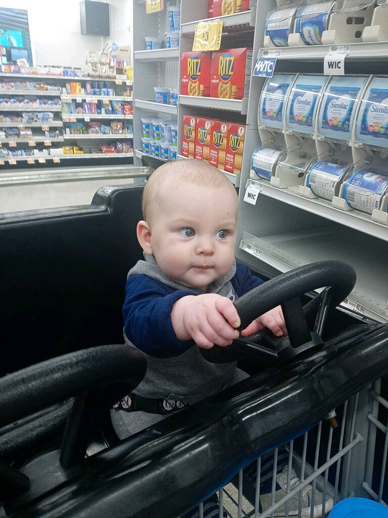 Drayden is registered to the contest to win money with this photo: baby, baby_toddler_clothing, blue, child, convenience_store, customer, electric_blue, gas, grocery_store, person, product, retail, service, shelf, shelving, shopping, shopping_cart, sitting, smile, t_shirt