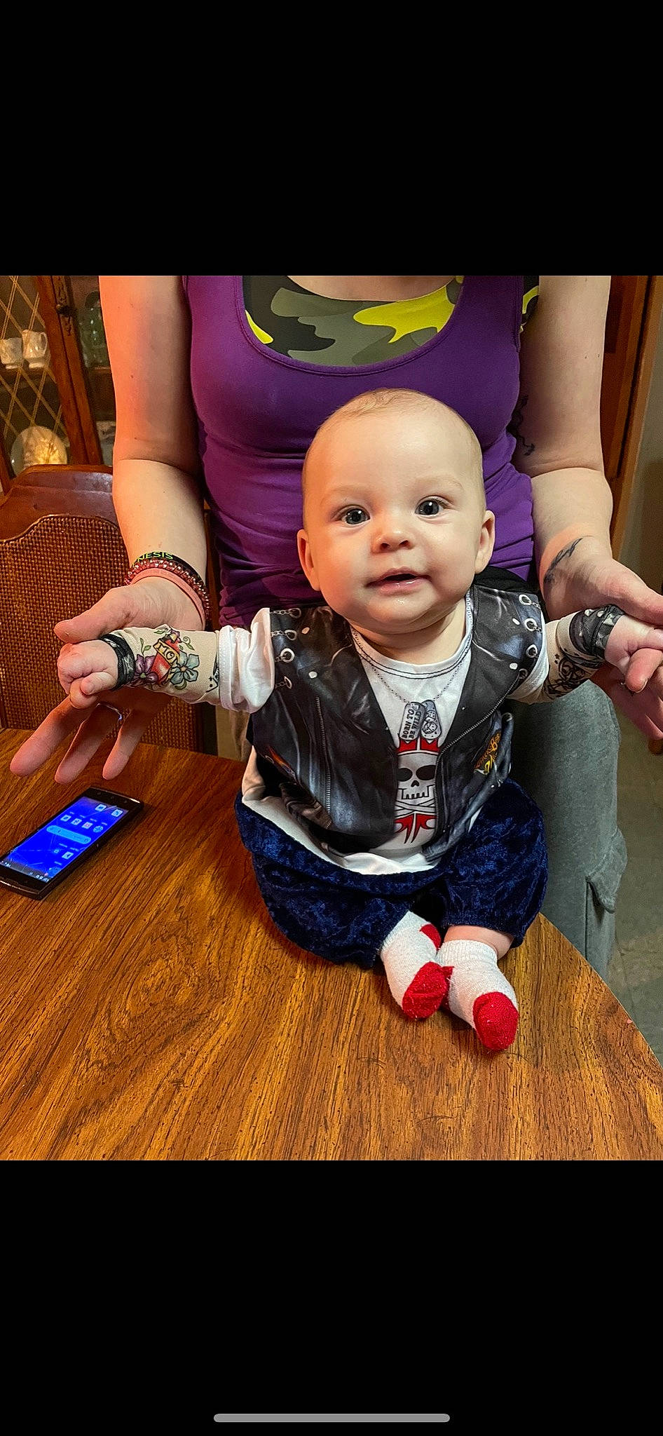 Drayden joined the competition — help win amazing prizes! baby, baby_toddler_clothing, child, finger, flooring, fun, hand, happy, hardwood, mobile_phone, person, sitting, skin, sleeve, smile, table, thumb, toddler, varnish, wood