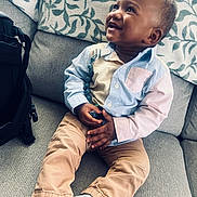 Makhii joined the competition — help win amazing prizes! toddler, child, smiling, sitting, couch, indoor, toy, clothing, pants, shirt, happy, face, feet, socks, home, blanket, cushion, person, portrait, comfort