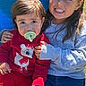 children, child, toddler, sibling, portrait, smiling, happy, pacifier, red_outfit, blue_seat, outdoor, sunlight, casual_clothing, girl, young, sitting, hugging, family, summer, photograph