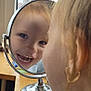 Lottie-Jae is registered to the contest to win money with this photo: child, mirror, smiling, reflection, face, window, earring, indoor, wooden_table, happy, young_child, person, portrait, curly_hair, closeup, natural_light, joy, expression, reflection_glass, metal_stand