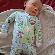 Luscious joined the competition — help win amazing prizes! baby, infant, child, sleeping, face, portrait, onesie, pajamas, green_clothing, cartoon_print, beach_theme, blanket, cushion, bed, indoor, lying_down, cozy, cute, head, photograph