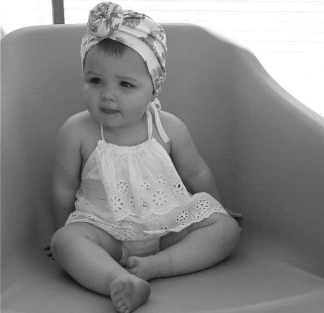 Chelsie participe au concours pour gagner de l'argent avec cette photo : baby, black_and_white, child, child_model, eye, face, hair_accessory, headgear, headpiece, leg, monochrome, monochrome_photography, person, photo_shoot, photograph, photography, sitting, skin, smile, toddler