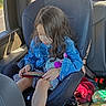 child, girl, car, car_seat, back_seat, portrait, sitting, gaming, handheld_device, denim_jacket, long_hair, face, plush_toy, toy, vehicle, interior, window, daylight, casual, travel