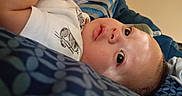 Elias joined the competition — help win amazing prizes! awake, baby, bed, blanket, child, close_up, clothing, curious, eyes, face, head, indoor, infant, lying_down, pacifier, patterned_fabric, photography, portrait, soft_lighting, striped_shirt