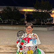 Nikola joined the competition — help win amazing prizes! child, birthday, cake, soccer, football, portrait, smiling, glasses, outdoor, night, celebration, sports_fan, soccer_ball, balloons, candles, table, wooden_table, stadium, trees, birthday_message