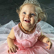 Louhann participe au concours pour gagner de l'argent avec cette photo : child, toddler, princess, tiara, pink_dress, smiling, happy, blue_eyes, curly_hair, necklace, floor, tiles, indoor, portrait, cute, baby, sitting, dress, celebration, joyful