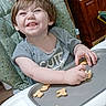 toddler, high_chair, smiling, snack, animal_crackers, indoor, kitchen, child, happy, eating, tray, person, short_hair, casual_clothing, furniture, home, cute, baby, seat, playful