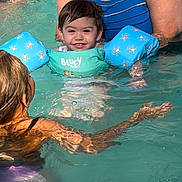 John is registered to the contest to win money with this photo: adult, blue, child, family, floaties, fun, green, happy, outdoor, people, playing, smiling, splashing, summer, support, swim_vest, swimming, swimming_pool, toddler, water