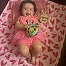 Lisa joined the competition — help win amazing prizes! baby, blanket, clothing, crown, curly_hair, cute, girl, happy, hearts, indoor, infant, lying_down, milestone, pink, plush, seven_months, smile, toy, tutu, wooden_plaque