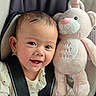 baby, infant, child, smiling, happy, portrait, car_seat, seatbelt, plush_toy, teddy_bear, pink, indoors, close_up, face, eyes, mouth, clothing, sweater, vehicle, photography